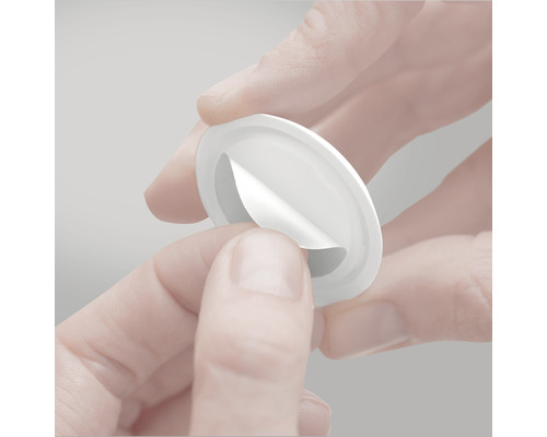 Een ronde, afpelbare kleefpad wordt in de hand gehouden.