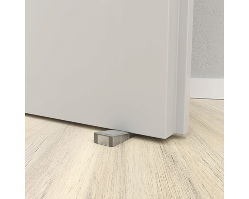 Deurstopper onder een deur op een houten vloer