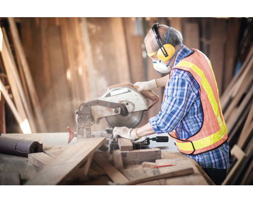 Vakman met veiligheidsmaatregelen tijdens houtbewerking met een cirkelzaag