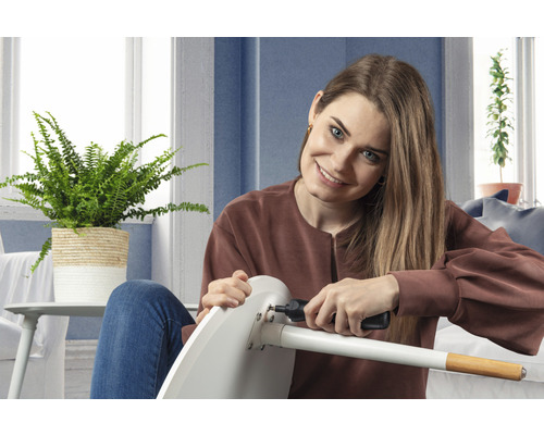 Een vrouw monteert een stoel met een accuschroevendraaier.