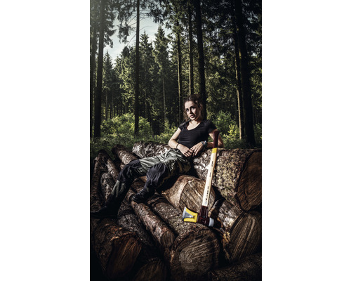 Vrouw rust uit op een stapel hout met een bijl in het bos