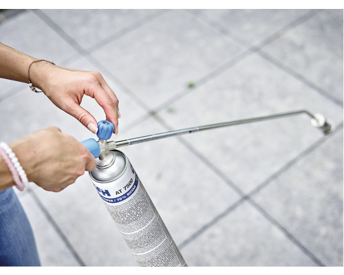 Vrouw bevestigt branderkop op een gasfles