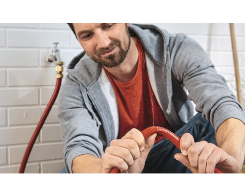 Man inspecteert een lekkende waterslang