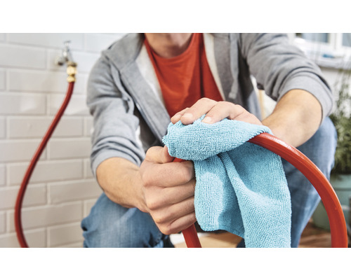 Een persoon maakt een slang schoon met een doek