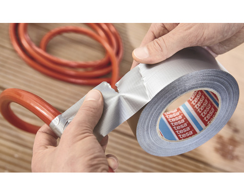 Een rol Tesa ducttape wordt gebruikt om een slang te repareren.