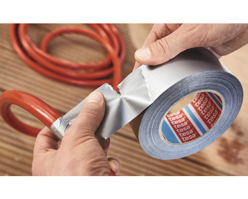 Een rol Tesa duct tape wordt gebruikt om een slang te repareren.