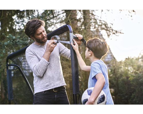 Vader en zoon repareren een voetbaldoel met tape