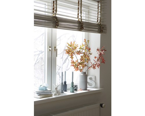 Raamdecoratie met jaloezieën, vaas met takken, kaarsen en decoratieve objecten op de vensterbank