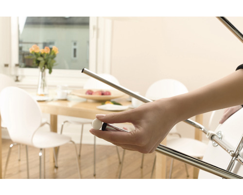 Iemand houdt een meubelglijder vast die aan een stoel wordt bevestigd om vloeren te beschermen.