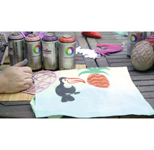 Spuitverf en sjabloon bij het ontwerpen van een stof met tropische motieven