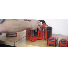 Acculader met meerdere accu''s op een houten tafel.