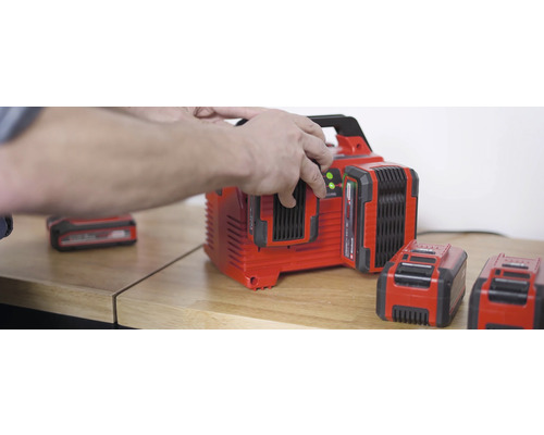 Acculader met meerdere accu''s op een houten tafel.