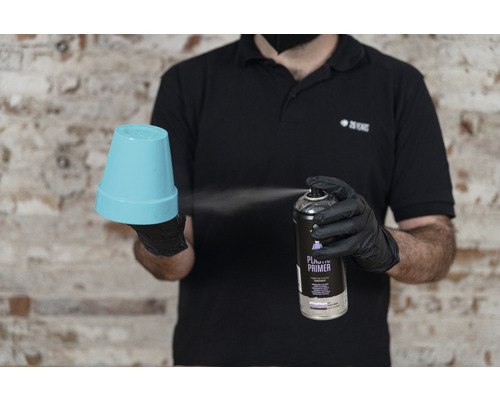 Iemand spuit plastic primer op een bloempot.
