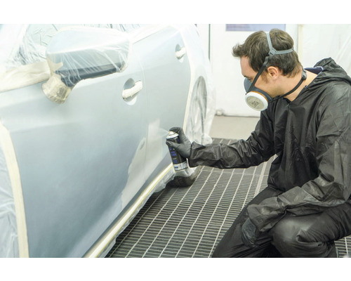 Man spuit auto met spuitbus