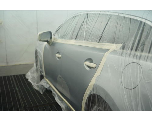 Auto voorbereid voor het spuiten, beschermd met afplakband en folie