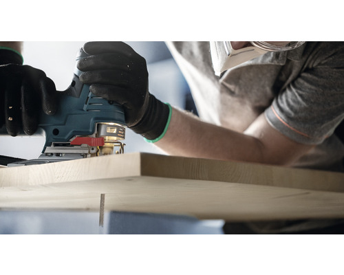 Een decoupeerzaag wordt gebruikt om een stuk hout te zagen.