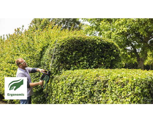 Man snoeit een heg met een heggenschaar. Ergonomisch symbool.