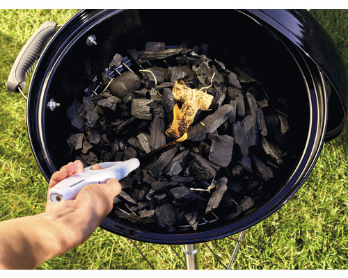 Aansteken van houtskool in een barbecue met een aansteker
