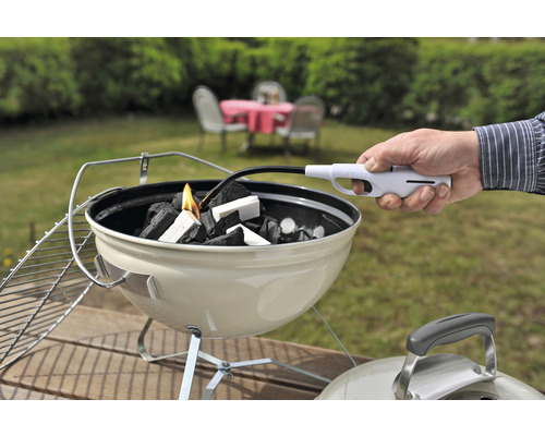 Aansteken van houtskool met een aansteker in een houtskoolbarbecue