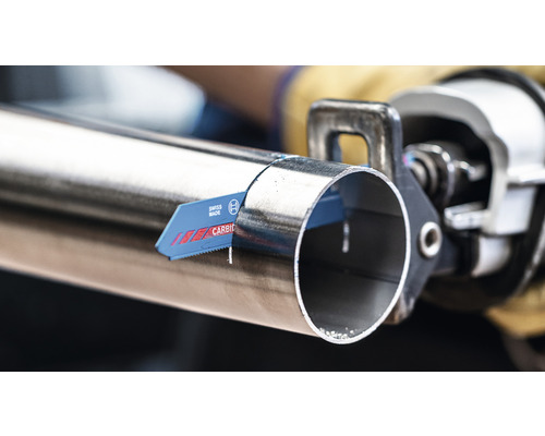 Een metaalzaag snijdt een metalen buis.