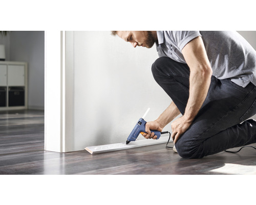 Man bevestigt plint met lijmpistool