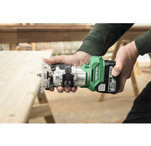 Personen houden een accubovenfrees van HiKoki boven een houten plank.