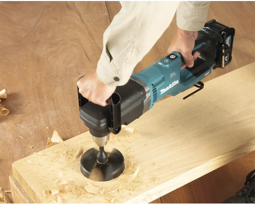 Persoon boort met een Makita boormachine een gat in een houten plank.