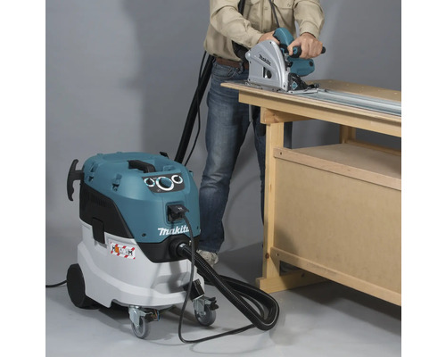 Scène met een persoon die een cirkelzaag gebruikt in combinatie met een industriële stofzuiger