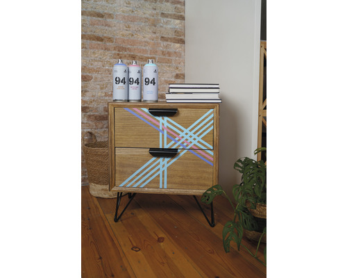 Houten commode met geometrisch patroon, spuitbussen en boeken