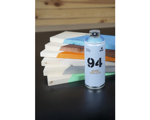 Een blik Montana 94 spuitverf naast beschilderde houten planken