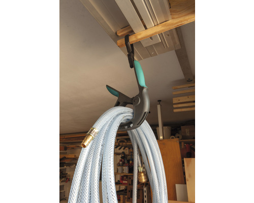 Een transparante waterslang hangt aan een klem voor opslag.