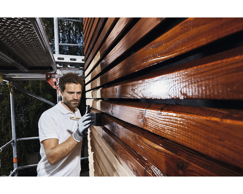 Man schildert houten gevel met houtbeschermingsbeits.
