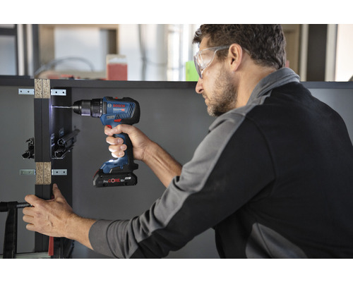 Man boort een werkstuk met een Bosch accuschroefboormachine.