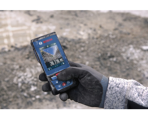 Bosch logo. Hand met handschoen houdt Bosch afstandsmeter vast met display met een meting van 28.776 meter
