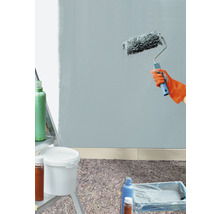 Muur schilderen met verfroller, verfemmer en afdekmateriaal op de vloer.