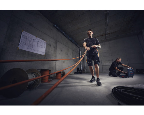 Elektriciens leggen kabels in een casco gebouw