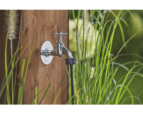 Tuinkraan met waterkraan en slangaansluiting op een houten wand