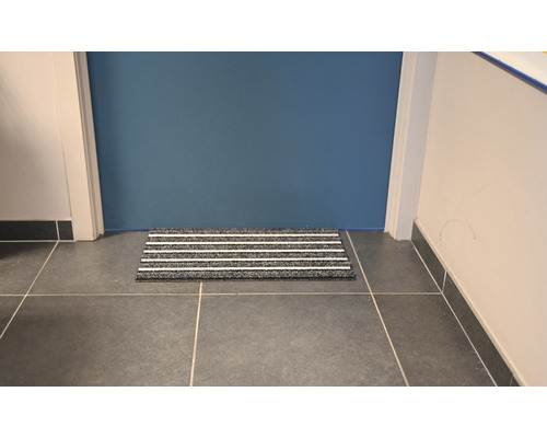 Deurmat met strepen voor een deur op een tegelvloer