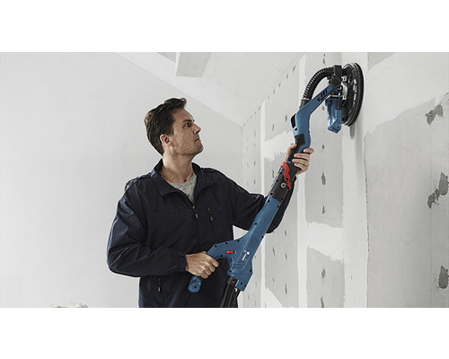 Man schuurt muur met een gipsplaats schuurmachine