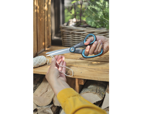 Iemand knipt een touw door met een Gardena universele schaar.