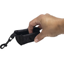 Zwarte poepzakjeshouder met karabijnhaak wordt vastgehouden door een hand