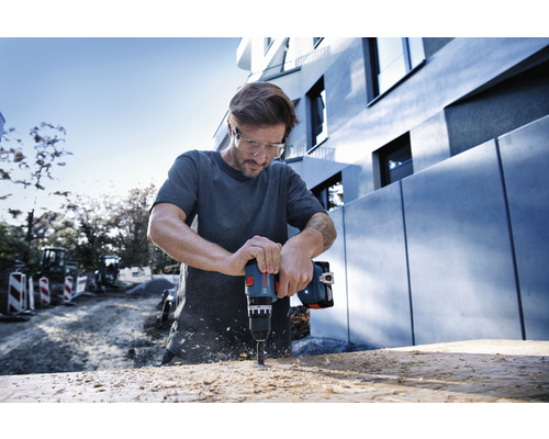 Man boort met accuschroefboormachine in hout