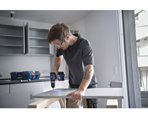 Man monteert een keukendeur met een accuschroefboormachine