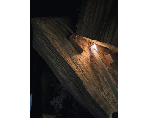 Een aansteker steekt hout aan.