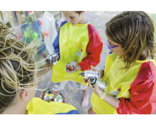Kinderen met spuitbussen en schilderschorten bij een kunstproject