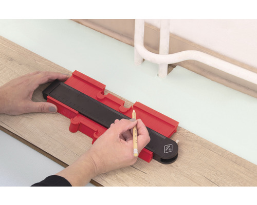 Persoon gebruikt een profielmal om op een houten vloer af te tekenen