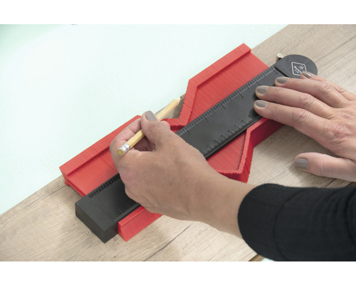 Een persoon gebruikt een profielmal om vormen over te brengen.