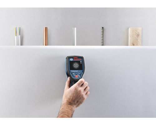 Hand houdt Bosch detector vast voor wandinspectie, voor het detecteren van elektrische leidingen, koperen buizen, kunststof buizen, staal en hout