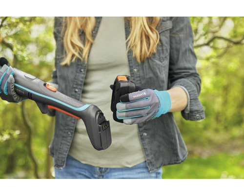 Vrouw plaatst accu in een Gardena accu grasschaar