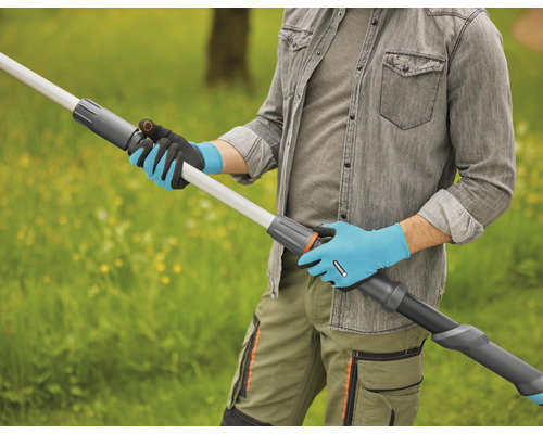 Een persoon met tuinhandschoenen houdt een telescopische steelverlenging buiten vast.